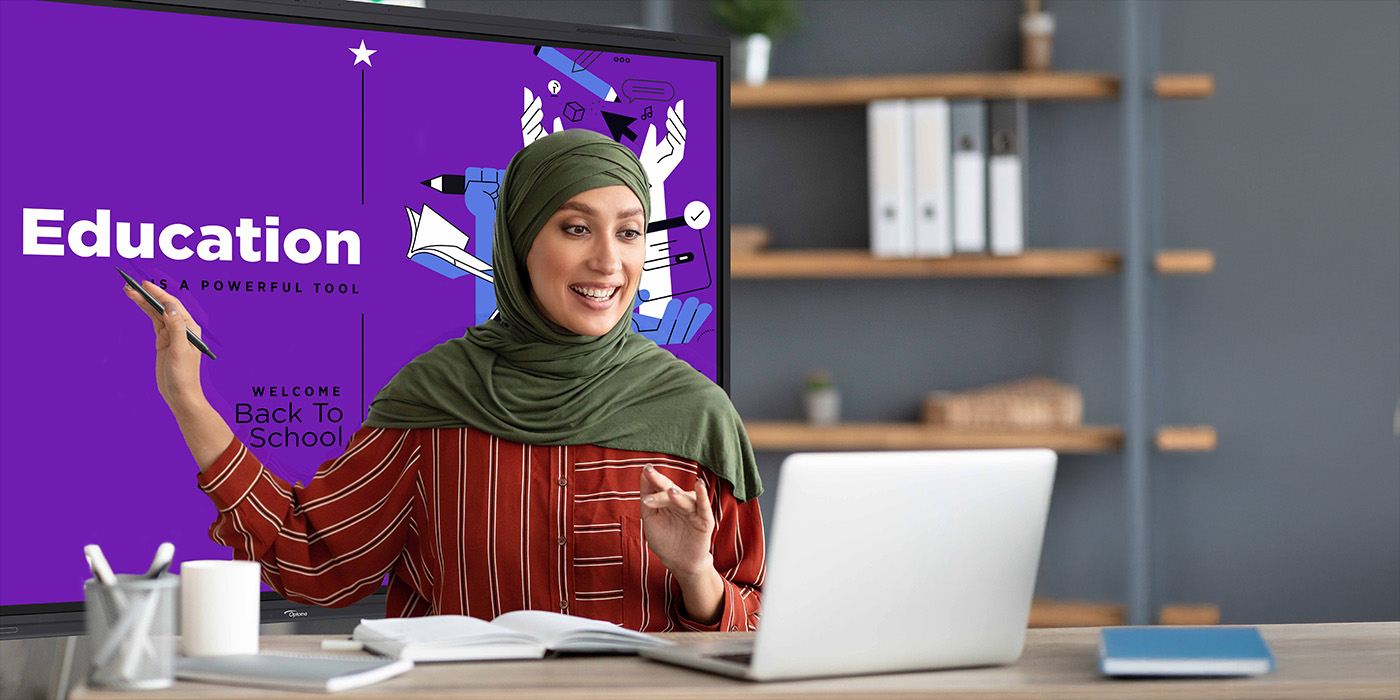 Female teacher in hijab presenting online lesson with education display screen and laptop