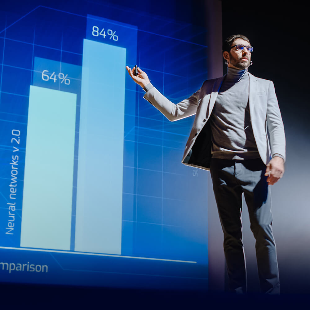 Professional presenter using large-scale interactive display technology to showcase business analytics and performance metrics. Advanced data visualization systems feature touch-enabled screens and real-time dashboard integration, perfect for corporate presentations, executive briefings, and data-driven decision making in modern meeting environments.