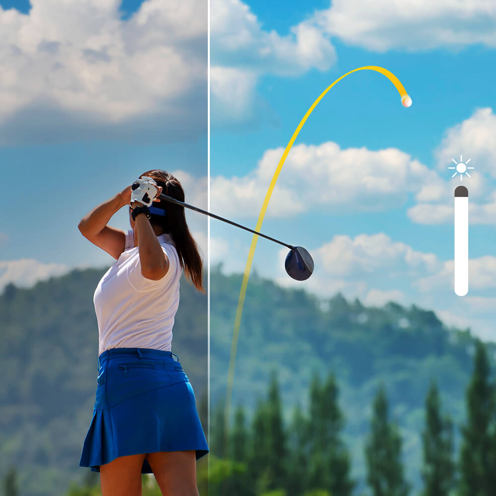Female golfer mid-swing on outdoor golf course with mountains in background
