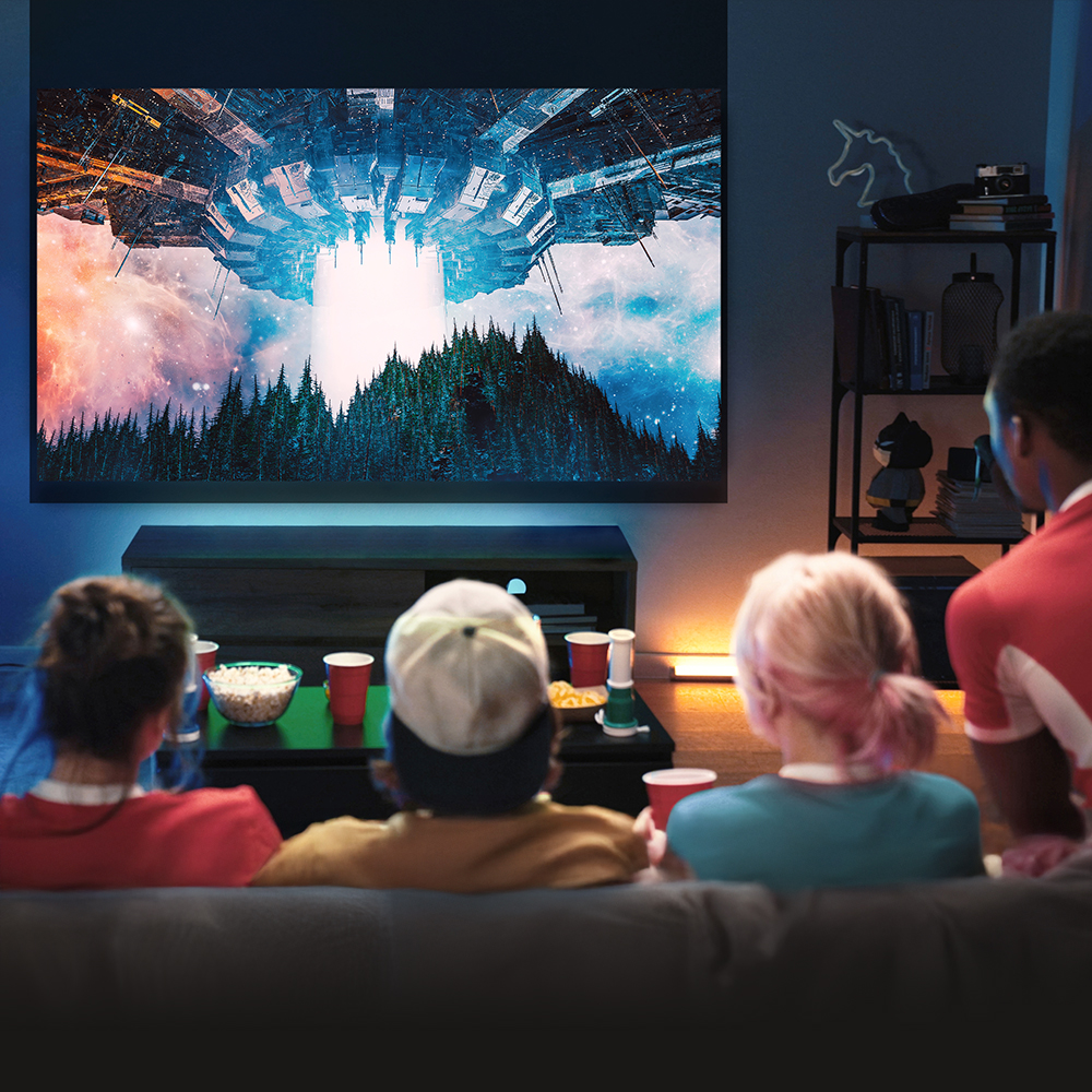 Group of friends watching a sci-fi movie in a modern home theater with a large projector screen, ambient lighting, and snacks – perfect indoor entertainment setup