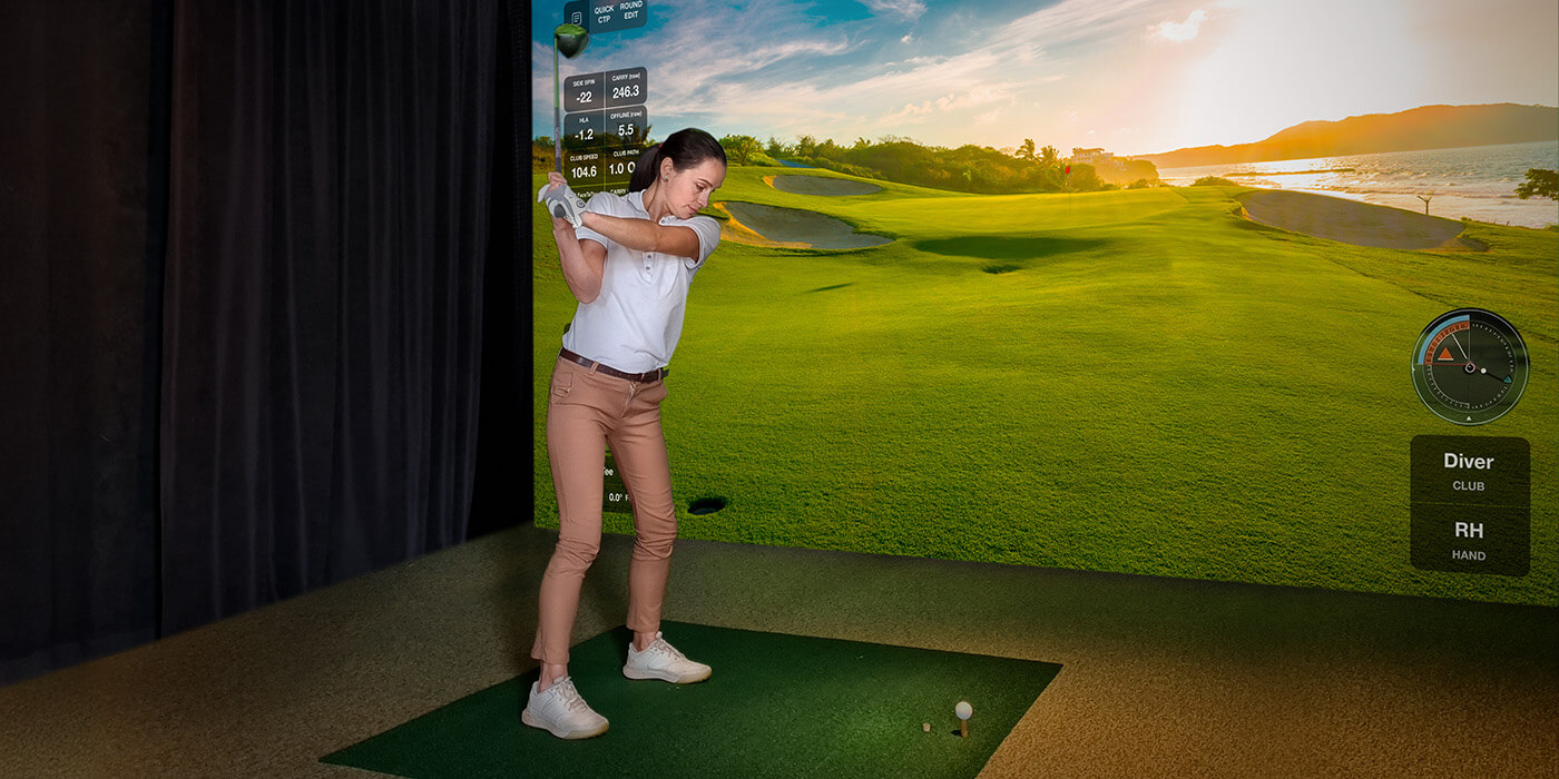 Female golfer using a high-definition indoor golf simulator with real-time data tracking, powered by Optoma projection technology for immersive sports training and entertainment.