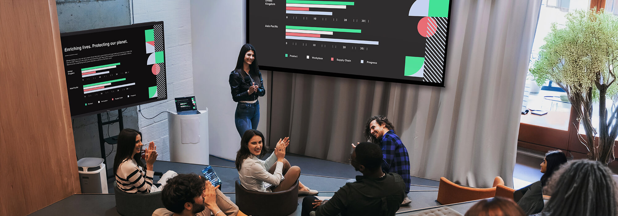 Business team collaborating in modern office meeting room with data analytics dashboards displayed on large screens, showing project management charts and progress tracking visualizations