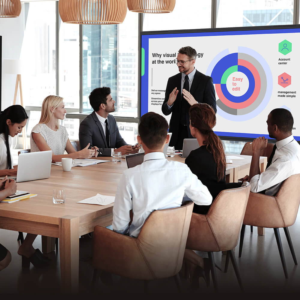 Business team in meeting room watching a visual presentation on data strategy and workplace collaboration.