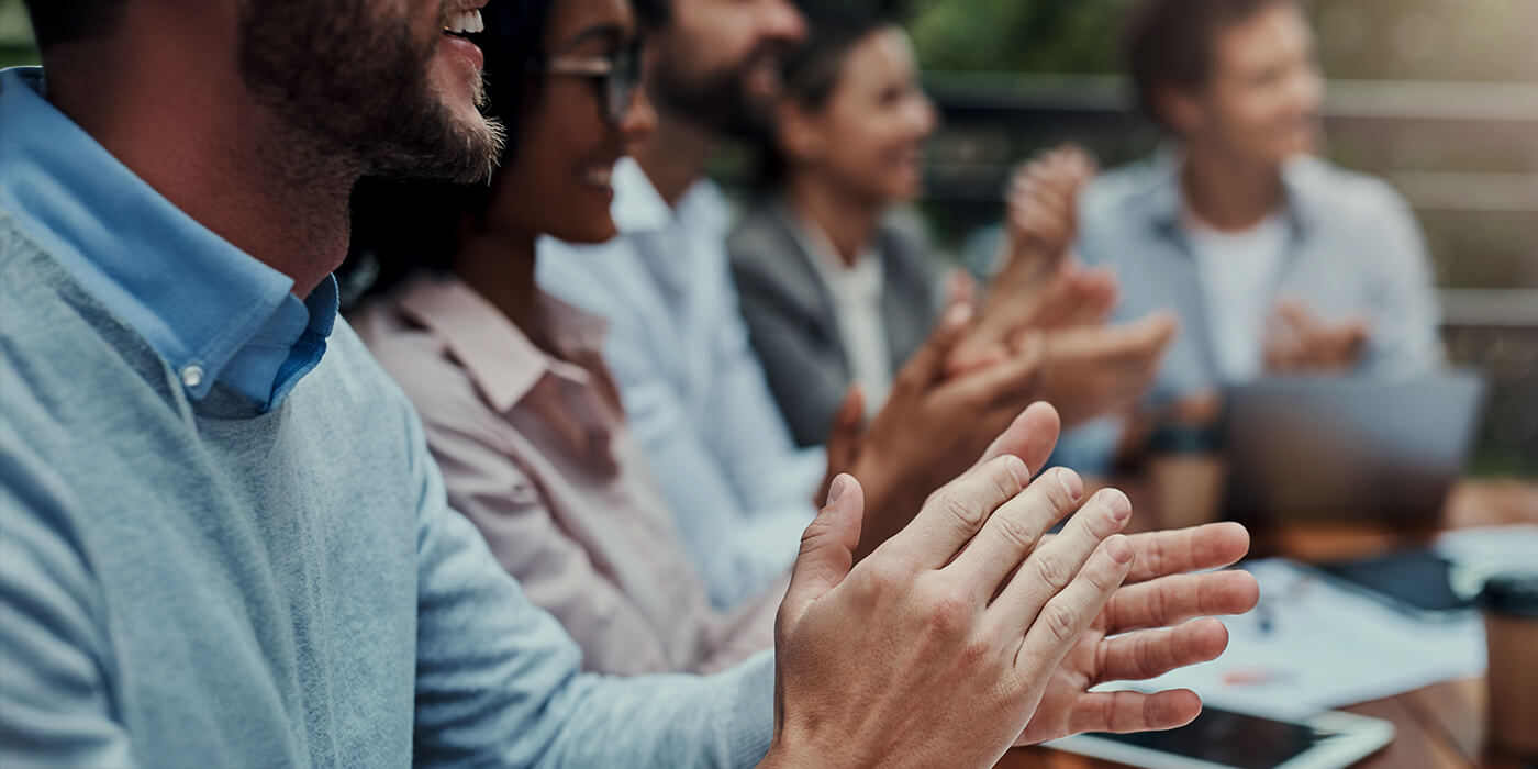 Business professionals applauding during corporate meeting or conference presentation