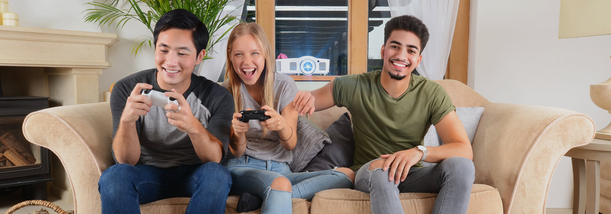 Diverse group of young adults gaming entertainment with wireless controllers and home projector setup in contemporary apartment living space