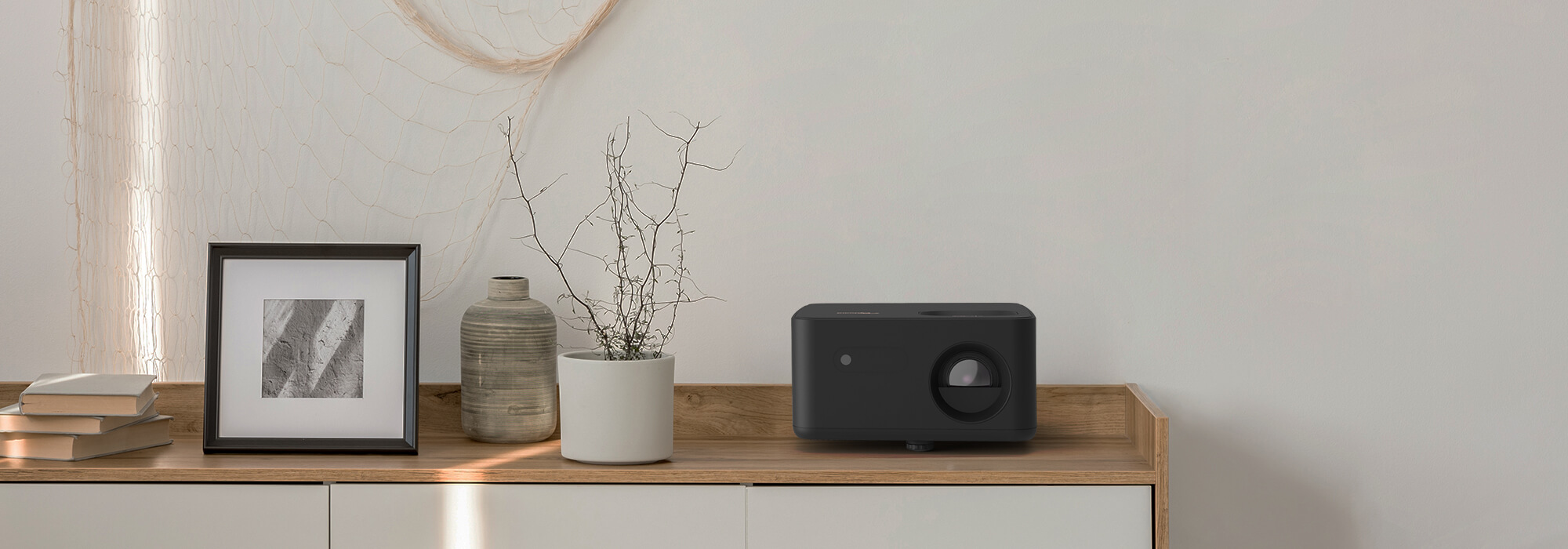 Compact Photon Life 4K UHD projector on furniture demonstrating portability and design