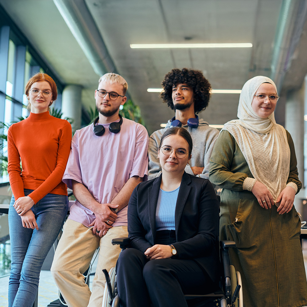 Diverse group of healthcare professionals and caregivers standing together in medical facility, representing inclusive patient care and healthcare teamwork