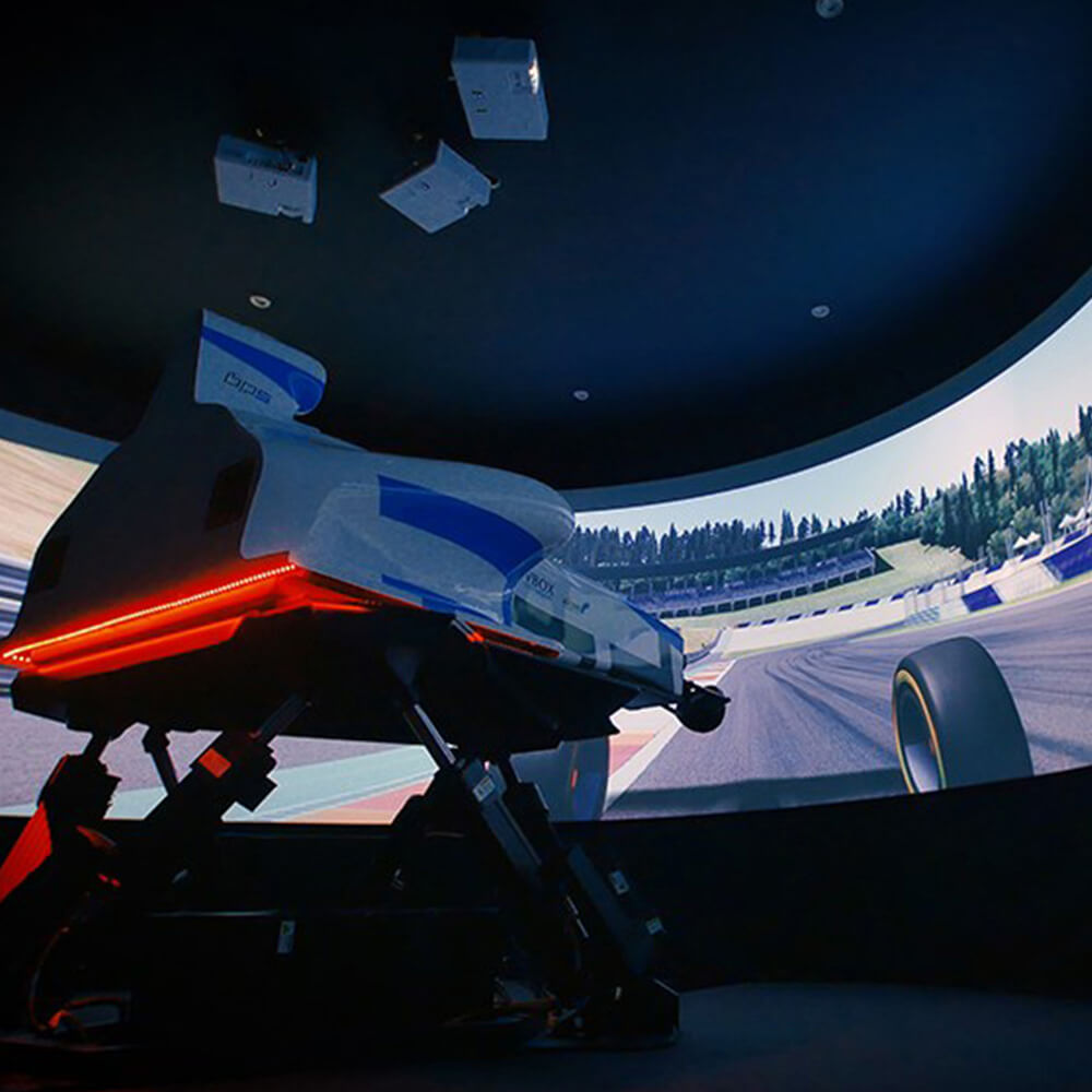 A sophisticated flight simulation setup with a pilot seated in a realistic cockpit, surrounded by curved projection screens displaying a snowy mountain landscape. The immersive 360-degree visual environment provides authentic training scenarios for aviation or an exhilarating virtual flying experience.